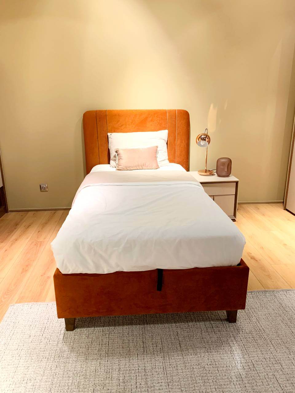 orange velvet single bed with white bedding