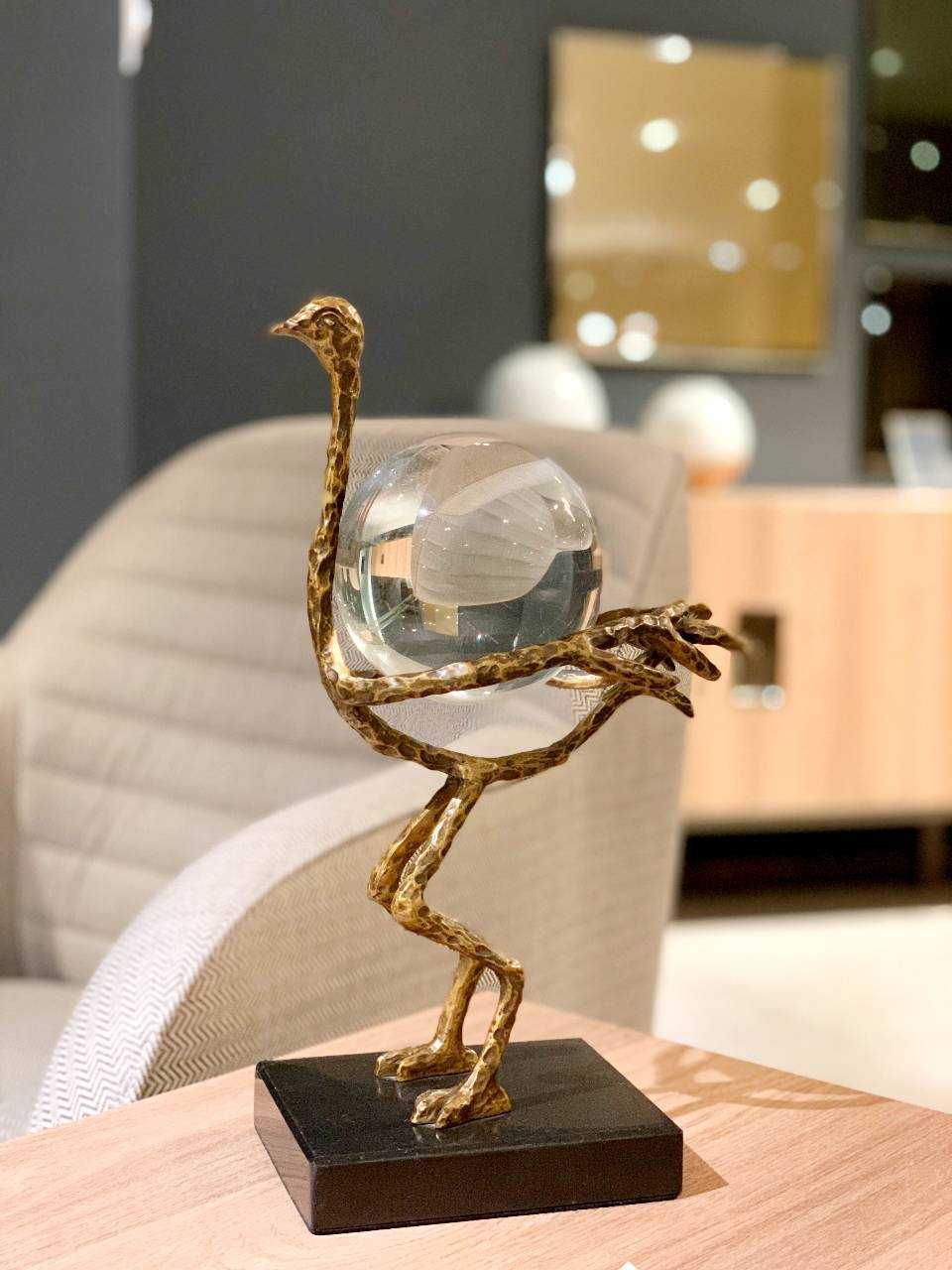 golden bird sculpture with a glass crystal