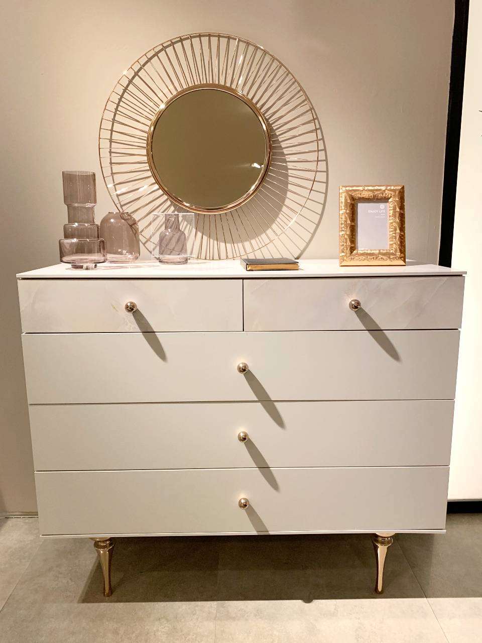 white dresser with gold knobs and metallic legs